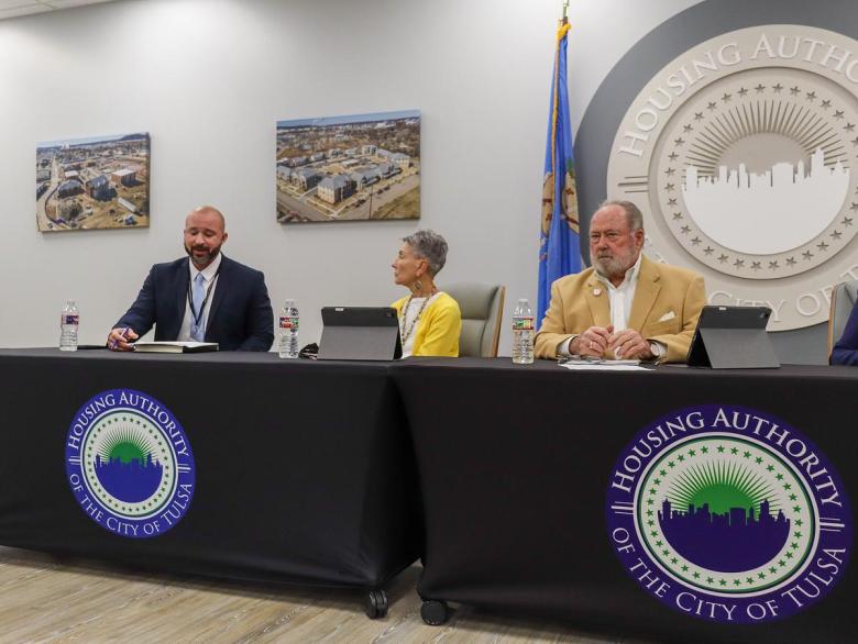 Tulsa Housing Authority CEO Aaron Darden, left, praises board chair Rick Neal, right, for his service to THA during a Thursday, Dec. 11, 2025, meeting.