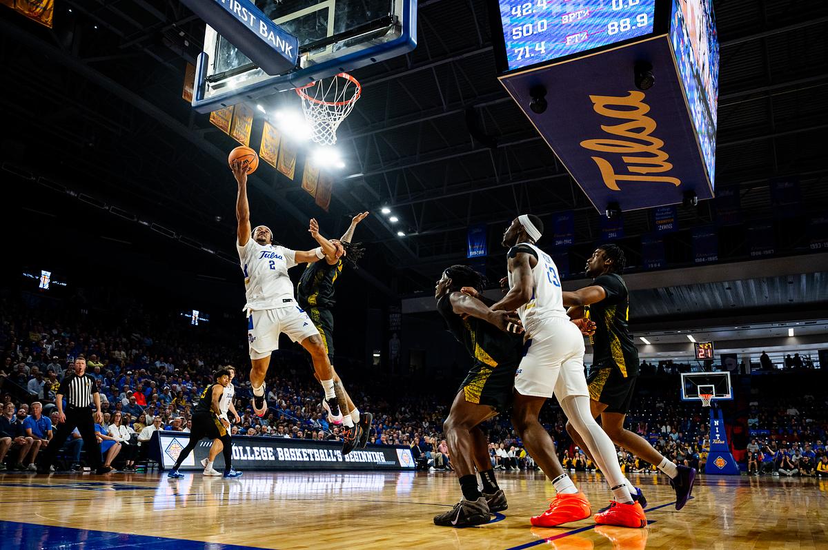 University of Tulsa’s Jaylen Lawal, left, shoots the ball while being guarded by a Wichita State defender during their game at the Donald Reynold’s Center on Tuesday, March 24, 2026.