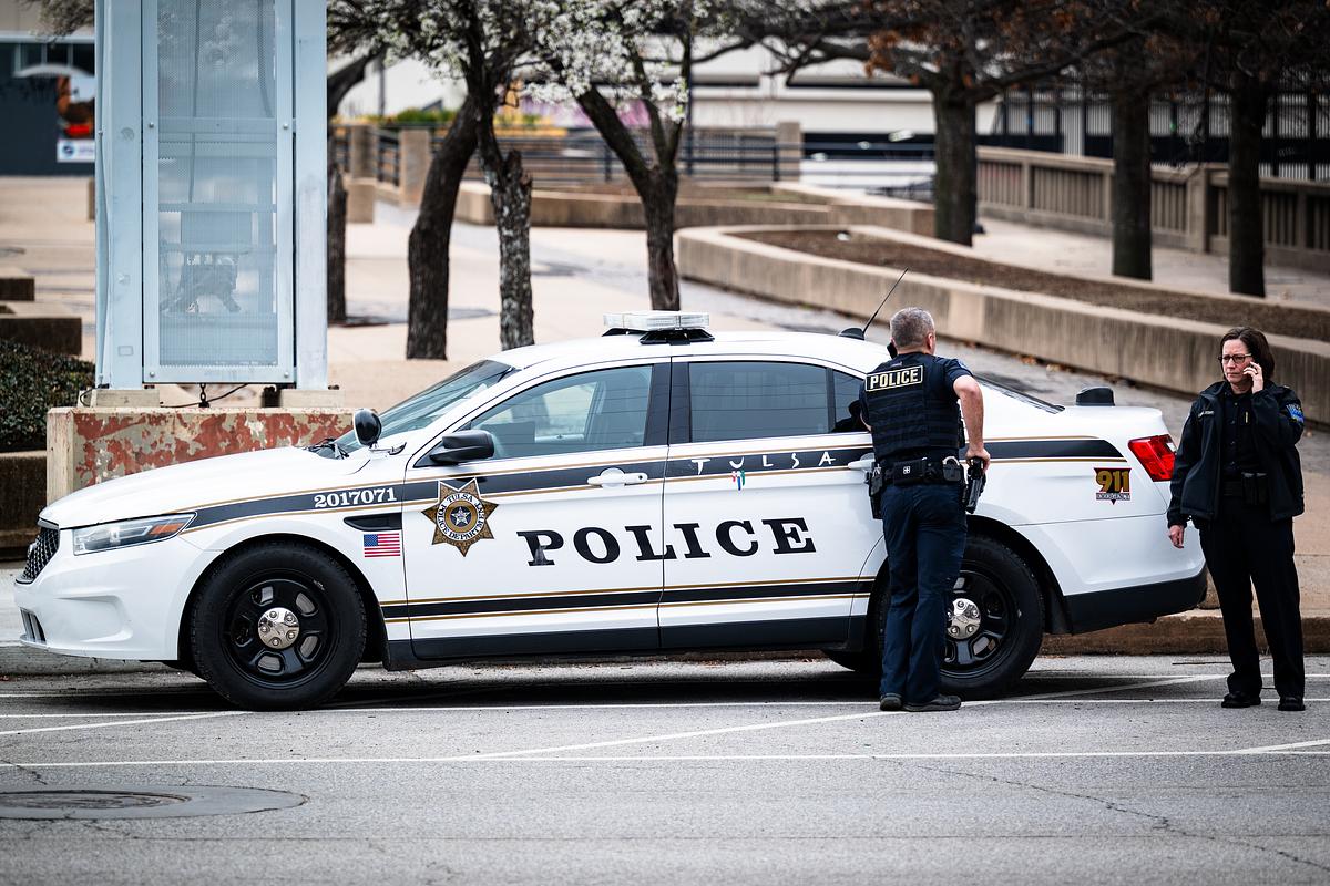 Tulsa police officers stand next to a patrol car near downtown March 5, 2026.