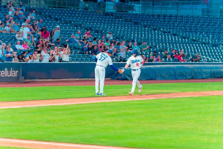Tulsa Drillers third-base coach Cordell Hippolito congratulates Drillers center fielder Zach Erhard after a home run against the Arkansas Travelers on Sept. 15, 2025.