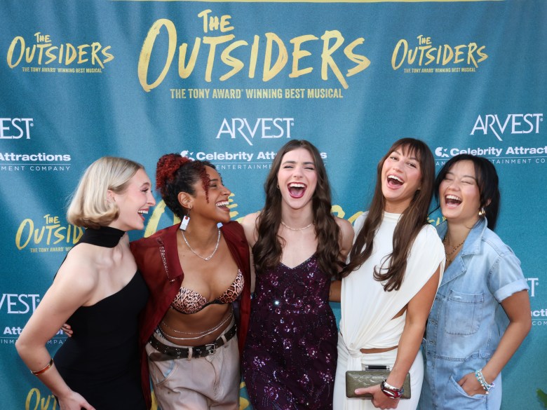 Cast members laugh on the red carpet at "The Outsiders: A New Musical" opening night celebration at Tulsa Performing Arts Center on Oct. 8, 2025.