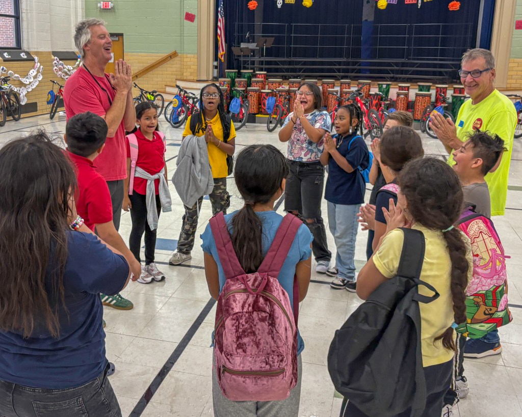Photo of children cheering at Celia Clinton's Bike Club.