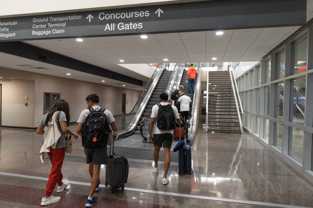 Travelers head up an escalator to a gate area at Tulsa International Airport on July 24, 2025.