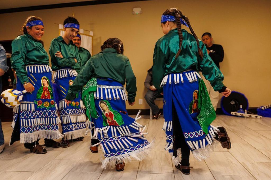 Left: Ma Luisa Robles, 47, and Miguel Vences, 18, watch as two of the younger dancers stomp on the ground and dance on Dec. 11 at St. Thomas More. The group has mixture of members from children as young as 5 years old.
