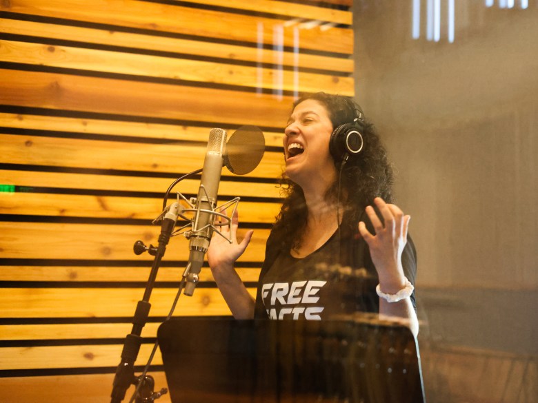 Woman sings inside recording studio