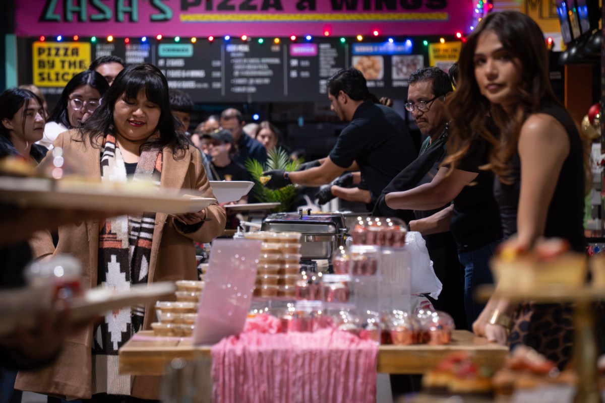 Attendees sample food during a El Programa de Lanzamiento graduation celebration at Mother Road Market on Dec. 16, 2025.