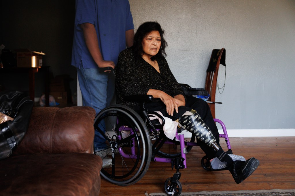 A man stands behind a woman in a wheelchair