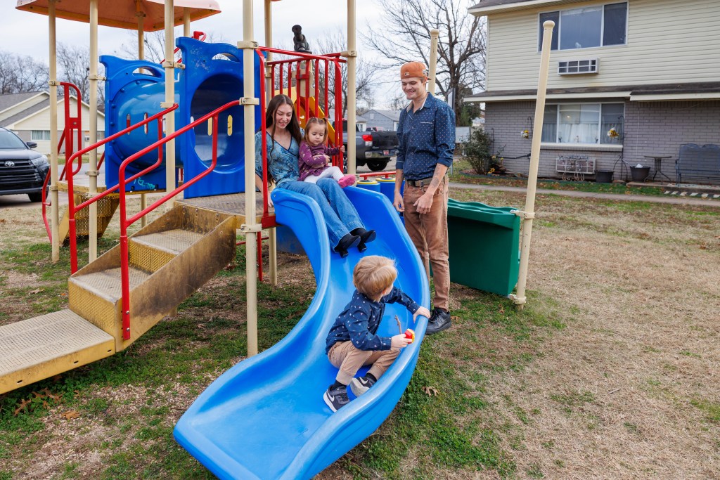 Family plays on a slide and playground