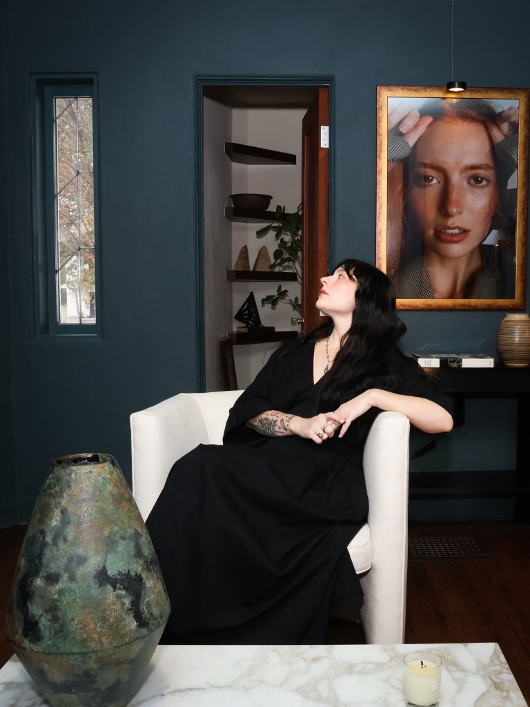 Woman stands in front of a portrait