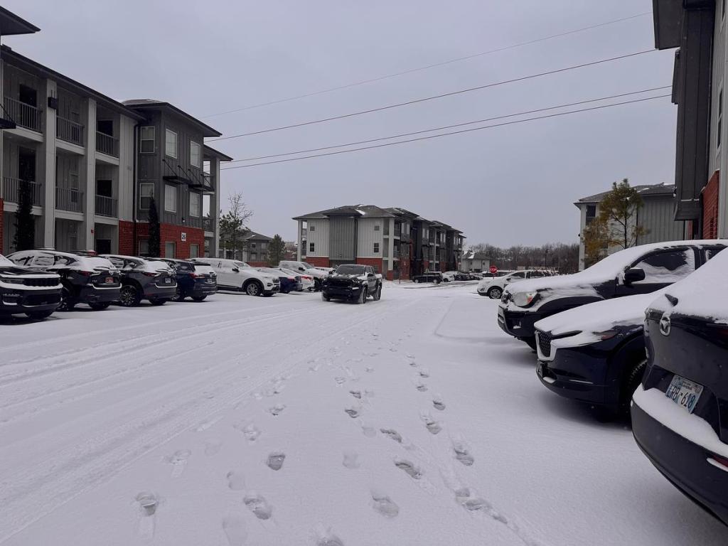 Snow covers cars in an apartment parking lot near 71st and Elwood Jan. 24, 2026.