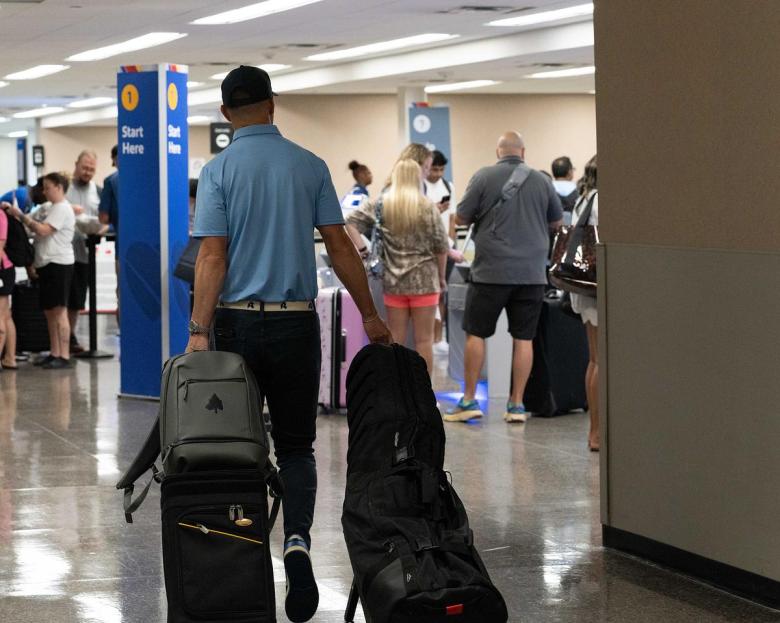 A traveler brings his carry-on bags and a set of gulf clubs to the Southwest Airlines check-in area at Tulsa International Airport July 24, 2025.
