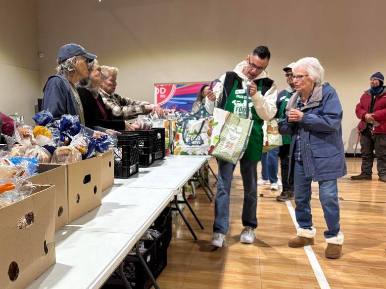 A volunteer helps Ramona Owens (right) through the Food on the Move grocery giveaway Friday, Jan. 30, 2026. Owens is a life-long west Tulsa resident and remembers when there were four grocery stores in her neighborhood.