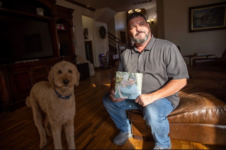 Man holding photo of wife