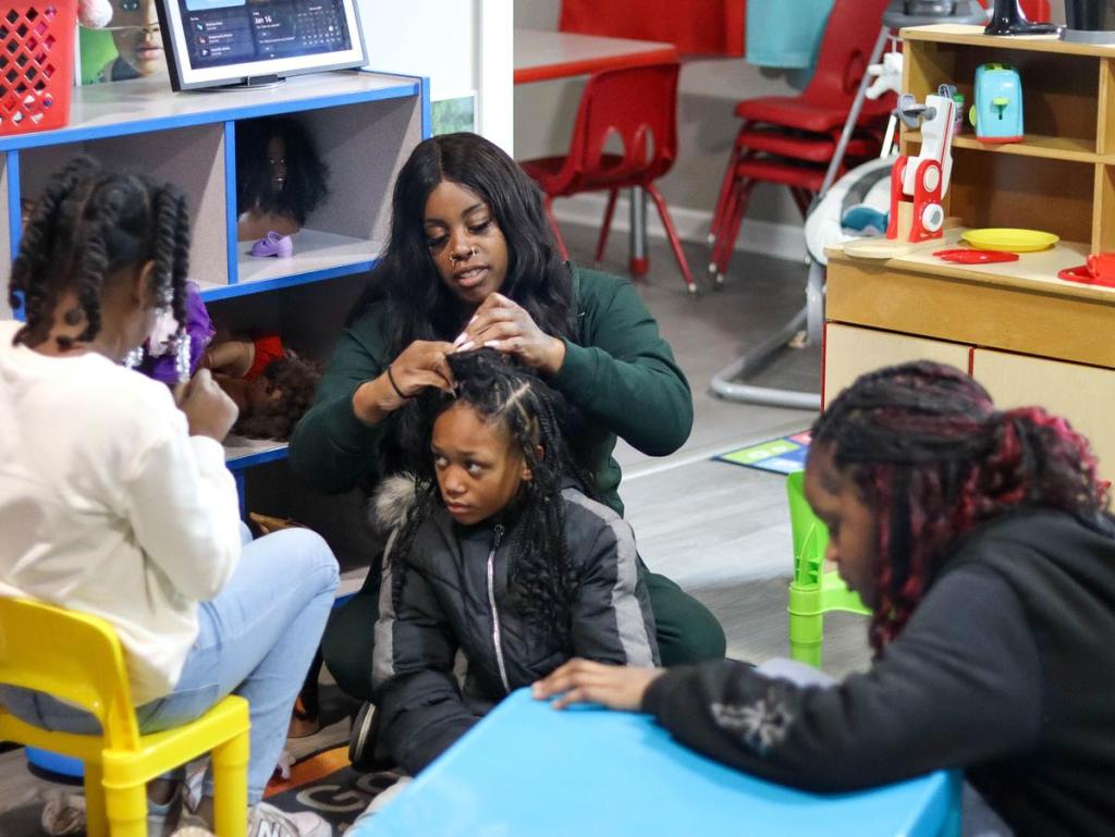 Ebony Fisher, Wykeyma Crockett's assistant, does Isabelle Adams' hair at their home day care in east Tulsa, Jan. 16, 2026. Fisher has worked with Crockett for over six years. 