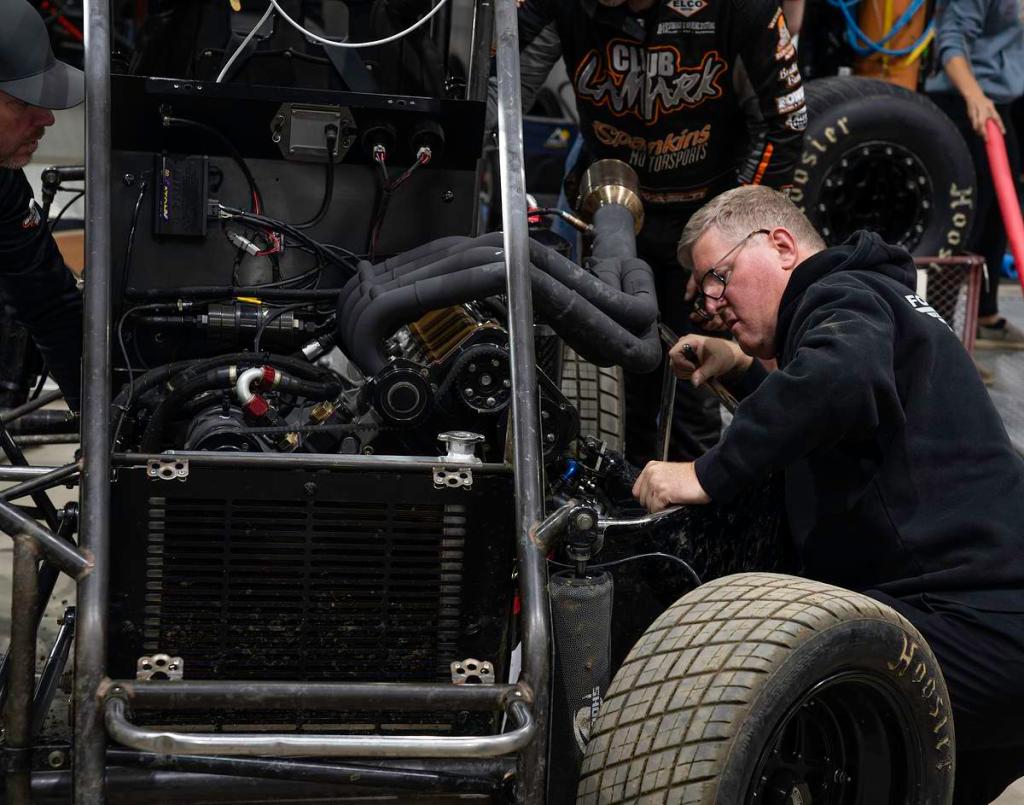 A team mechanic adjusts part of a car's suspension system in the pit areas of the 2026 Chili Bowl Nationals Jan. 14, 2026. The event draws drivers, vendors and racing fans from around the country for a full week.  