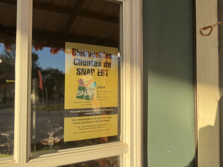 A sign welcoming SNAP customers hangs in a window.