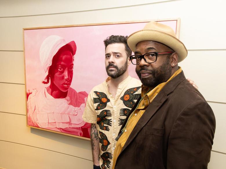 Artist Joel Daniel Phillips and poet Quraysh Ali Lansana stand in front of a Phillips portrait on display in "Killing the Negative: A Conversation in Art & Verse" at Philbrook Museum of Art on Feb. 20, 2026. Phillips' art is paired with poetry by writers like Lansana.