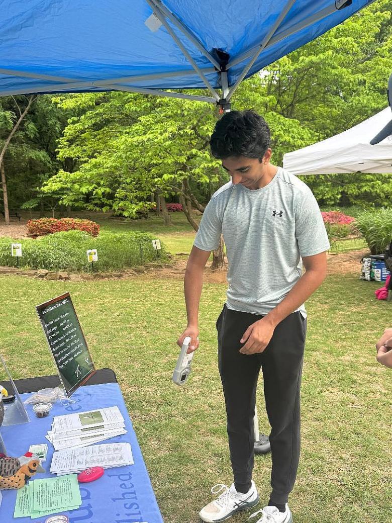 Tej Beniwal volunteers at an event at Ray Harral Nature Center in Broken Arrow. The device he is squeezing compares hand strength to the talon strength of various species of birds.