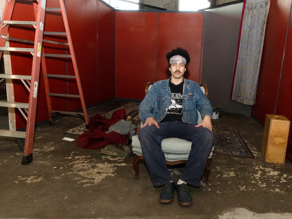 Man sits inside art exhibition booth
