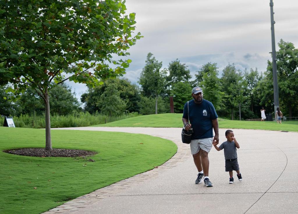 A father and son walk through The Gathering Place on June 30, 2025.