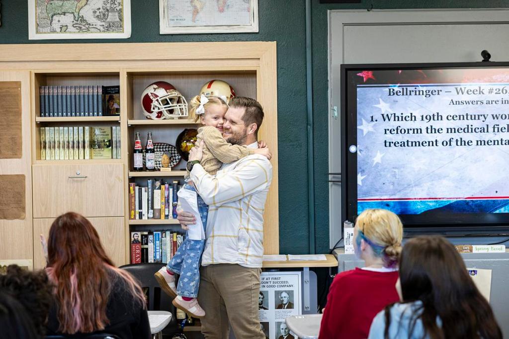 Kraig Mewbourne, a middle school teacher at Tulsa Edison Preparatory School, holds one of his children after being surprised by Tulsa Public Schools Superintendent Ebony Johnson with his nomination for 2026 Teacher of the Year on Thursday, March 12, 2026, at Tulsa Edison Preparatory School in Tulsa, Oklahoma.
