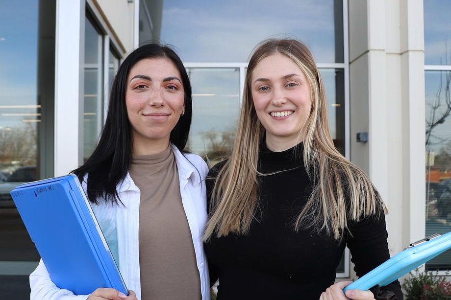 Rachel Wimp, left, and Clara Anderson pose for a photo in front of the Family & Children Services’ call center. The two regularly respond to mental health crisis calls for the 988 hotline.