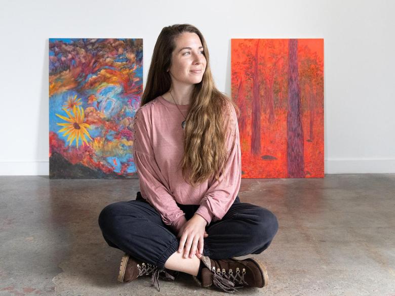 Liz Dueck sits with her paintings on display at Positive Space Tulsa March 11, 2026. The nature artist's exhibit "A Year of Embodied Art" runs through March 28.