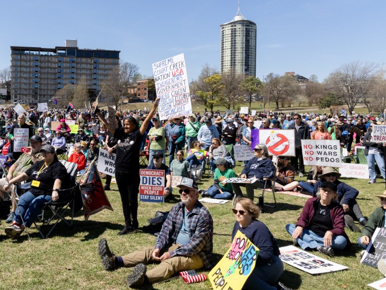 people hold protests signs at dream keepers park