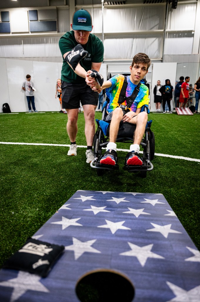 Hayden Crawford, left, helps his brother Holden Crawford play cornhole during a Special Olympics Unified Cornhole Tournament at Tulsa's Nathan Hale High School March 26, 2026.