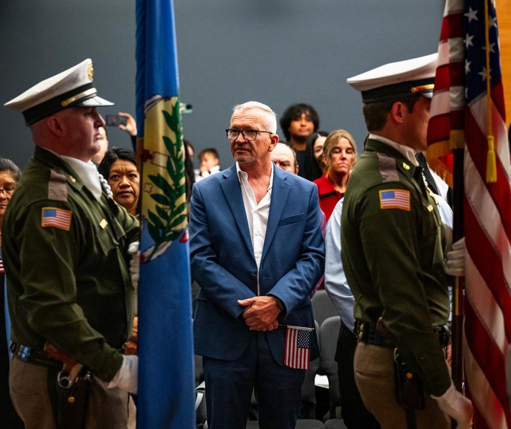 Olaf Christein from Germany stands during the presentation of colors during a naturalization ceremony at City Hall on Thursday, April 9, 2026. 
