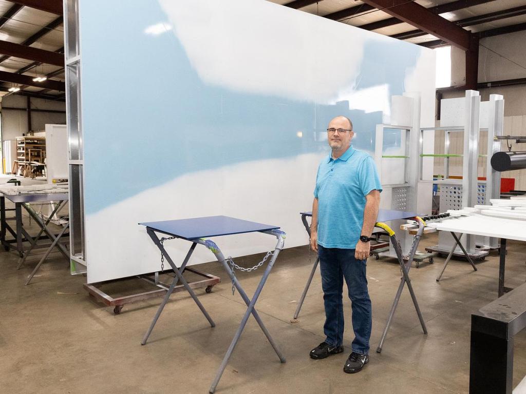 Joe Kesterson, a designer for Claude Neon Federal, stands in front of a piece of signage soon headed to be a part of the Blue Whale of Catoosa's new visitor center. 