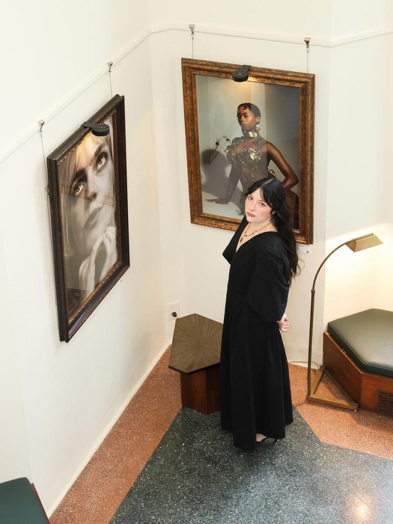 Photographer Taylor Mae Villarreal stands among her "Faces" portraits before a private showing at Oath Studio on Dec. 6, 2025. The portraits will be for sale Jan. 23-24 at Carson House. 
