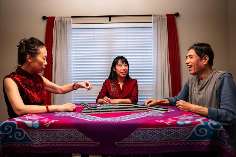 From left: Xuemei Zhao, Alpha Zhang and Sterling Chen play traditional Chinese mahjong  in east Tulsa April 1, 2026.