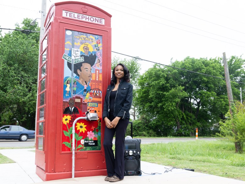Artist Atoni Fowlkes stands next to her new art display on the outside of a phone booth next to Stutts House of Barbeque after it was unveiled on April 16, 2026.