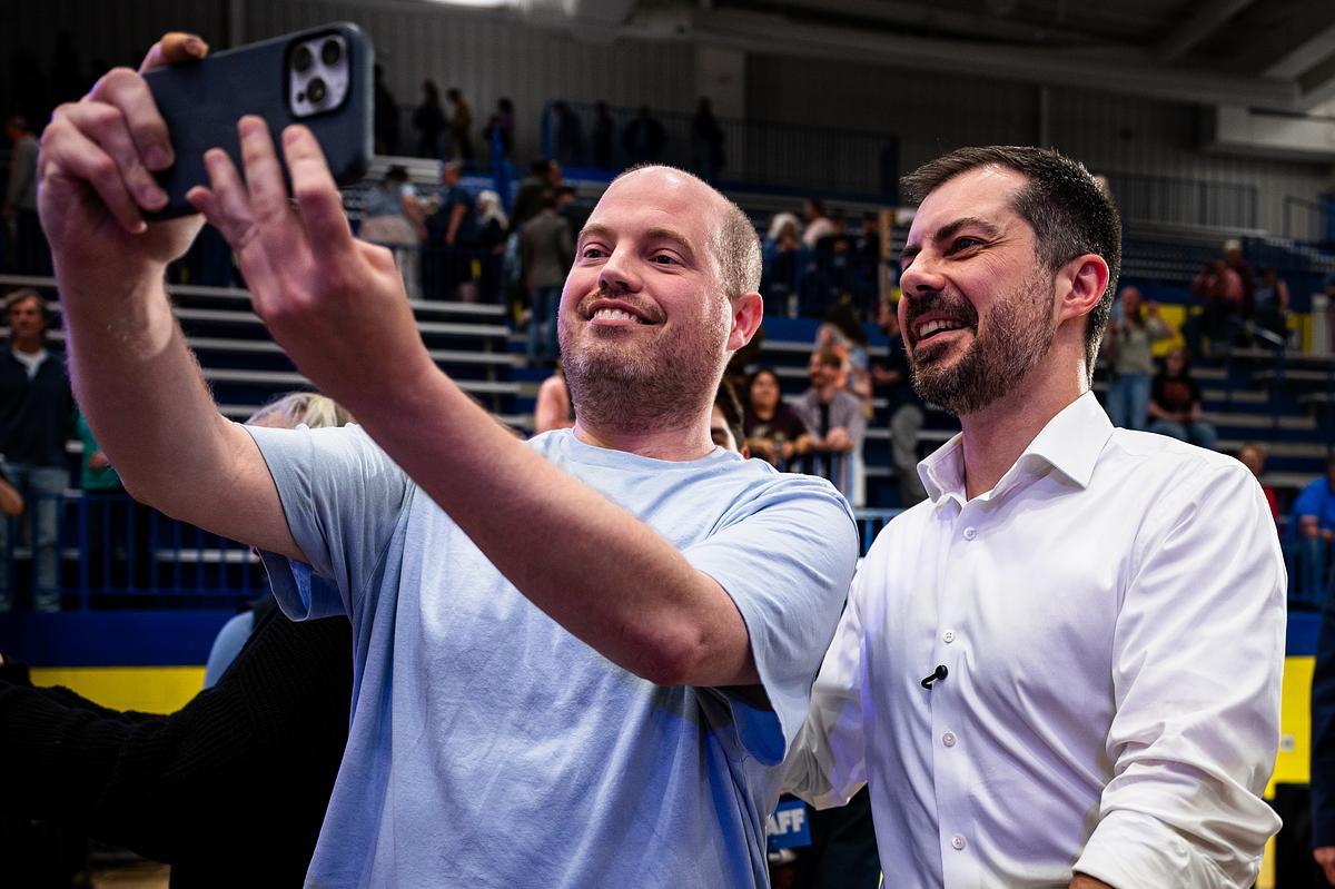 Former U.S. Secretary of Transportation Pete Buttigieg, right, takes a photo with a fan after speaking at Will Rogers High School on Saturday, April 18, 2026.