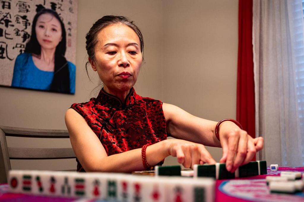 Xuemei Zhao plays mahjong April 1, 2026. Zhao spoke fondly about learning to play the game as a young child in China. She misses the more expanded version of the game that included extra tiles and the seasons of the year.  