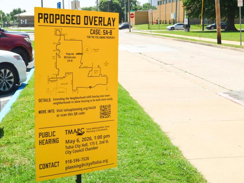 A sign outside the Rudisill Regional Library notifies the public of the Tulsa Metropolitan Area Planning Commission's May 6, 2026, public hearing on the neighborhood infill overlay expansion proposal.