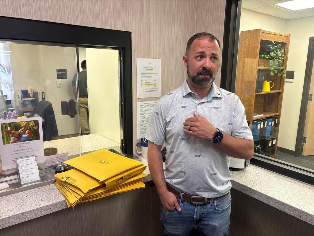 Kyle Schmidt of the Protect Sand Springs Alliance stands in front of the city clerk's window March 31, 2026, moments before delivering signatures from thousands of residents demanding a recall of Sand Springs elected officials.
