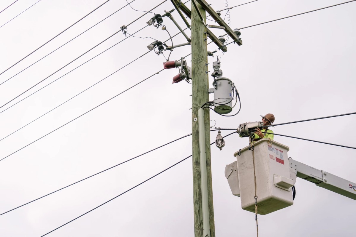 A utility worker installs a high-speed internet cable.