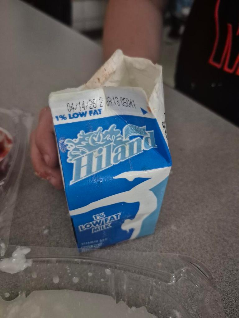 Tulsa Changemakers inspect a milk carton before a club meeting April 14, 2026. They opened the milk on its expiration date to find chunks and a sour smell.