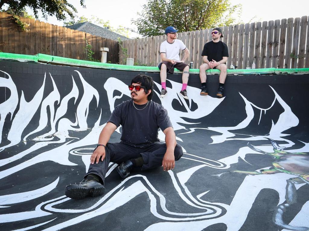 VNICE World is pictured in July 2025 at the pool mural he created for Art House Tulsa. The artist collaborated with the east Tulsa group on Studio 1801, a space at 1801 S. Garnett Road.