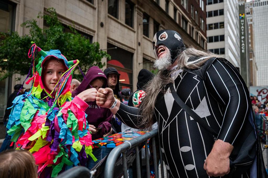 A fan shares a moment with a Luchador wrestler during the Cinco De Mayo Luchador Wrestling event outside Elote Cafe & Catering on Tuesday, May 5, 2026.
