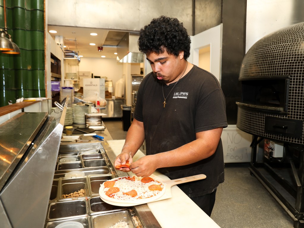 Lollipops Woodfire & Grocery Chef Desmond Shields preps a pizza on May 20, 2026.