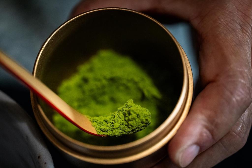 Yumie Farringer scoops matcha out of the container during a traditional matcha tea ceremony at her home on Tuesday, April 21, 2026. 
