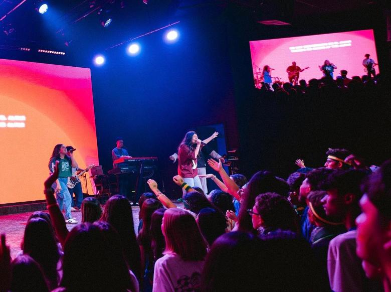 Areliz Fierro, center, leads worship during the Next Gen Victory Youth Conference. The three-day annual event brings together youth groups from churches across the Tulsa area.