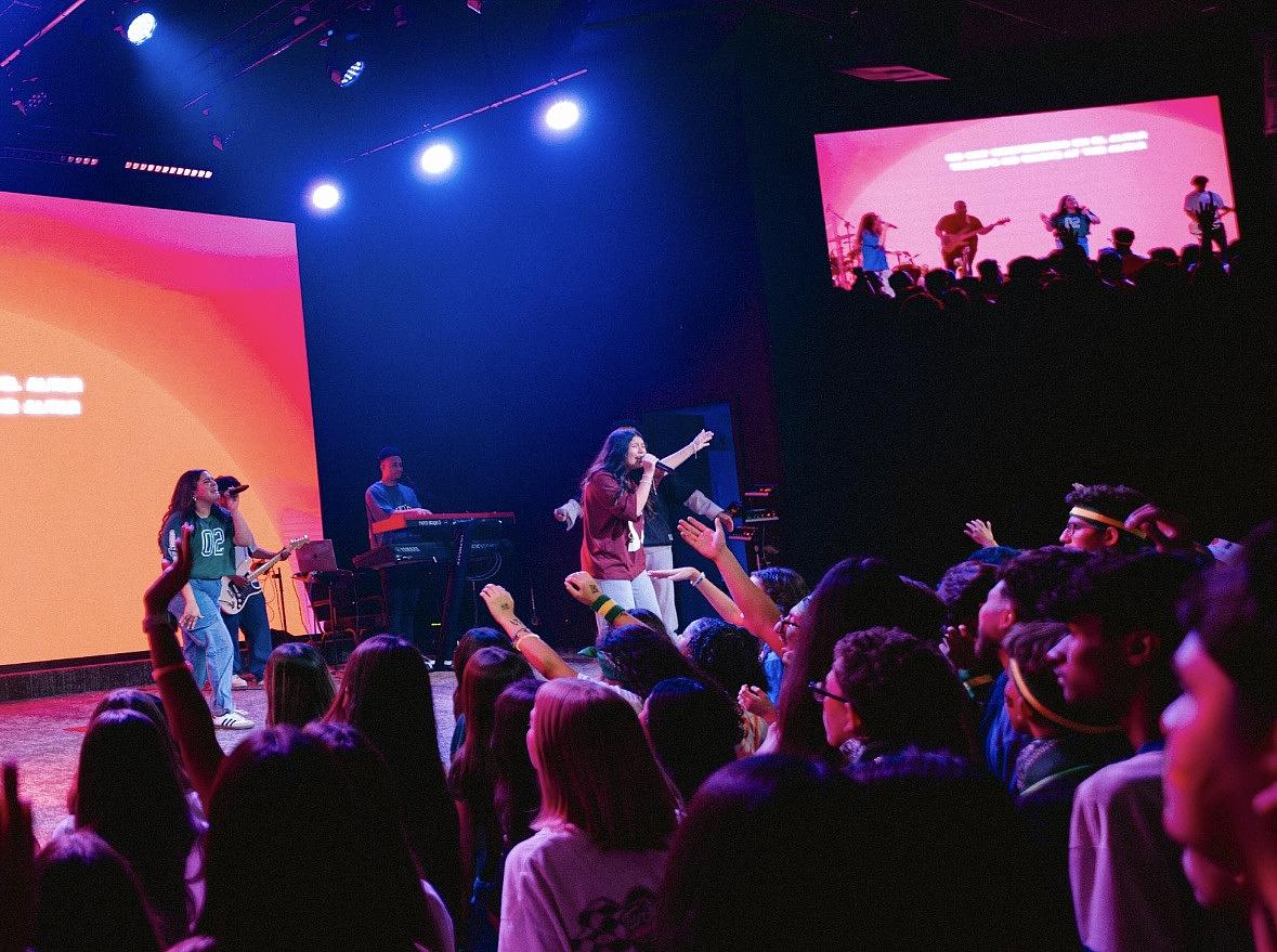 Areliz Fierro, center, leads worship during the Next Gen Victory Youth Conference. The three-day annual event brings together youth groups from churches across the Tulsa area.