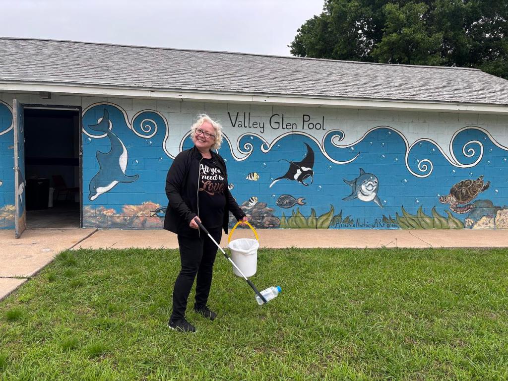 Michele Elkins, president of the Columbus Neighborhood Association, poses for a photo while picking up trash outside of the Valley Glen Pool entrance April 28, 2026. The association is planning to reopen the pool May 23. 