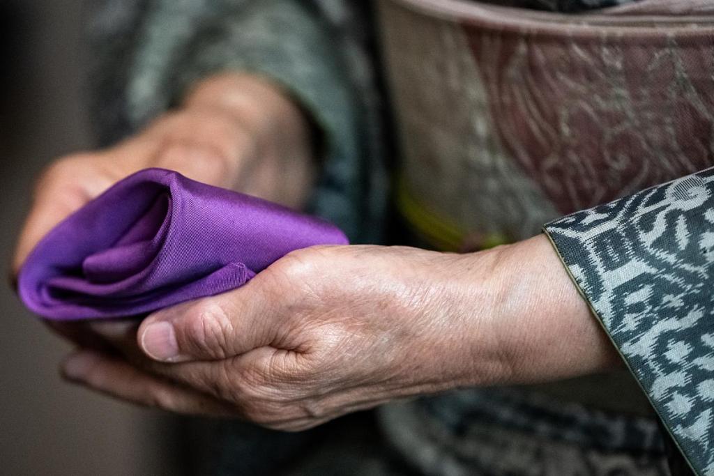 Yumie Farringer folds her cleaning towel during a traditional matcha tea ceremony at her home on Tuesday, April 21, 2026. The towel is supposed to purify each item used in the ceremony. The ceremony is grounding, peaceful and silent. It is a special ceremony she uses to welcome guests to her home. 