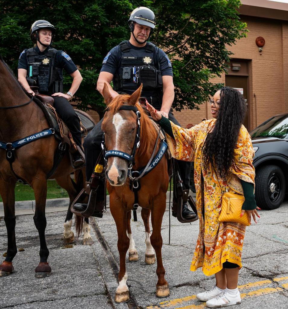 Tulsa Police officers Annika Tollefson riding Rosie watches Darin Howse riding Horsey as Brianna Peral pets Horsey on North Boston Avenue next to the Guthrie Green on Wednesday, May 20, 2026.