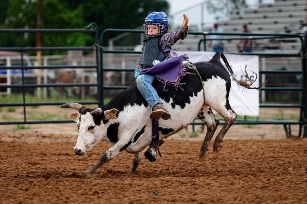 Carston Fry, age 9, rides a bull during the Muscogee Nation Festival in Okmulgee on Thursday, June 25, 2026. He has ridden around 100 bulls, today he rides a bull named Bannana.